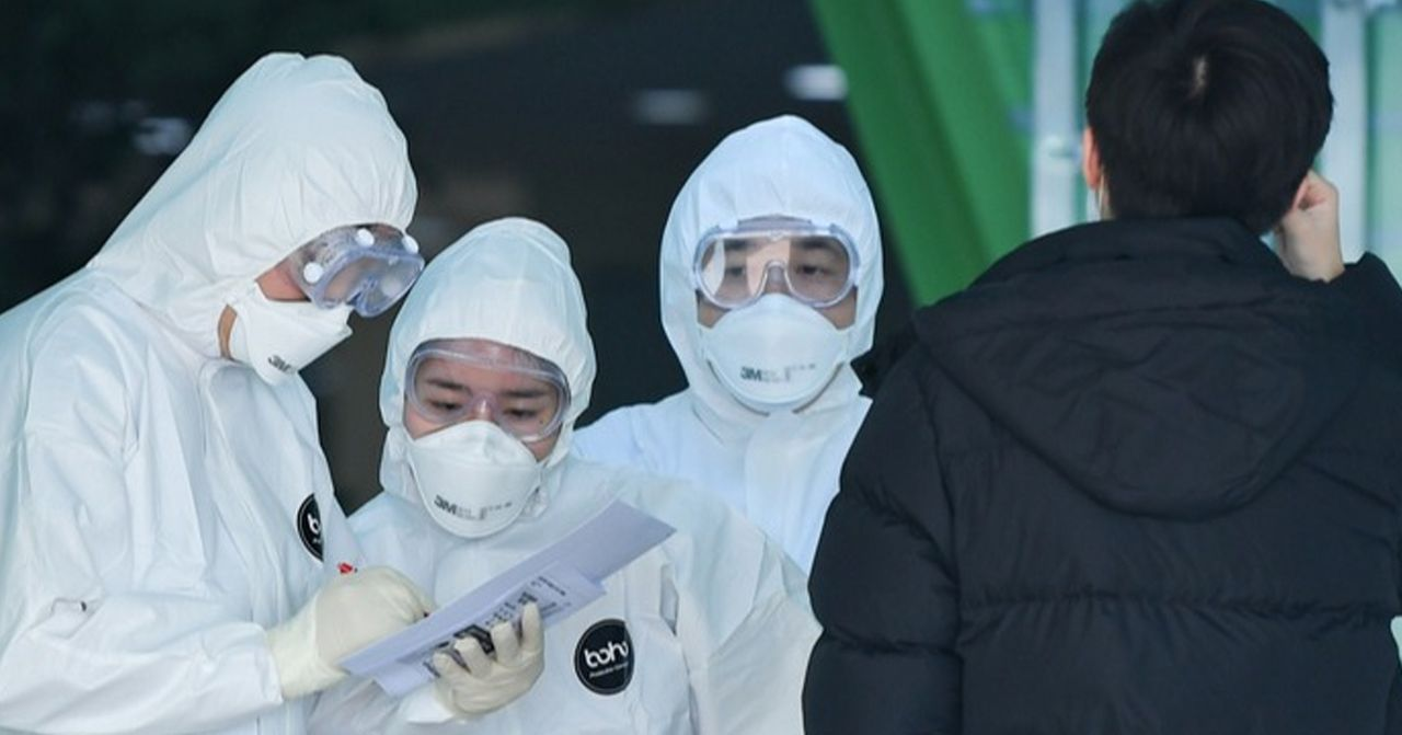 兩名醫護人員正在檢查一名市民的資料，確認其健康狀況。