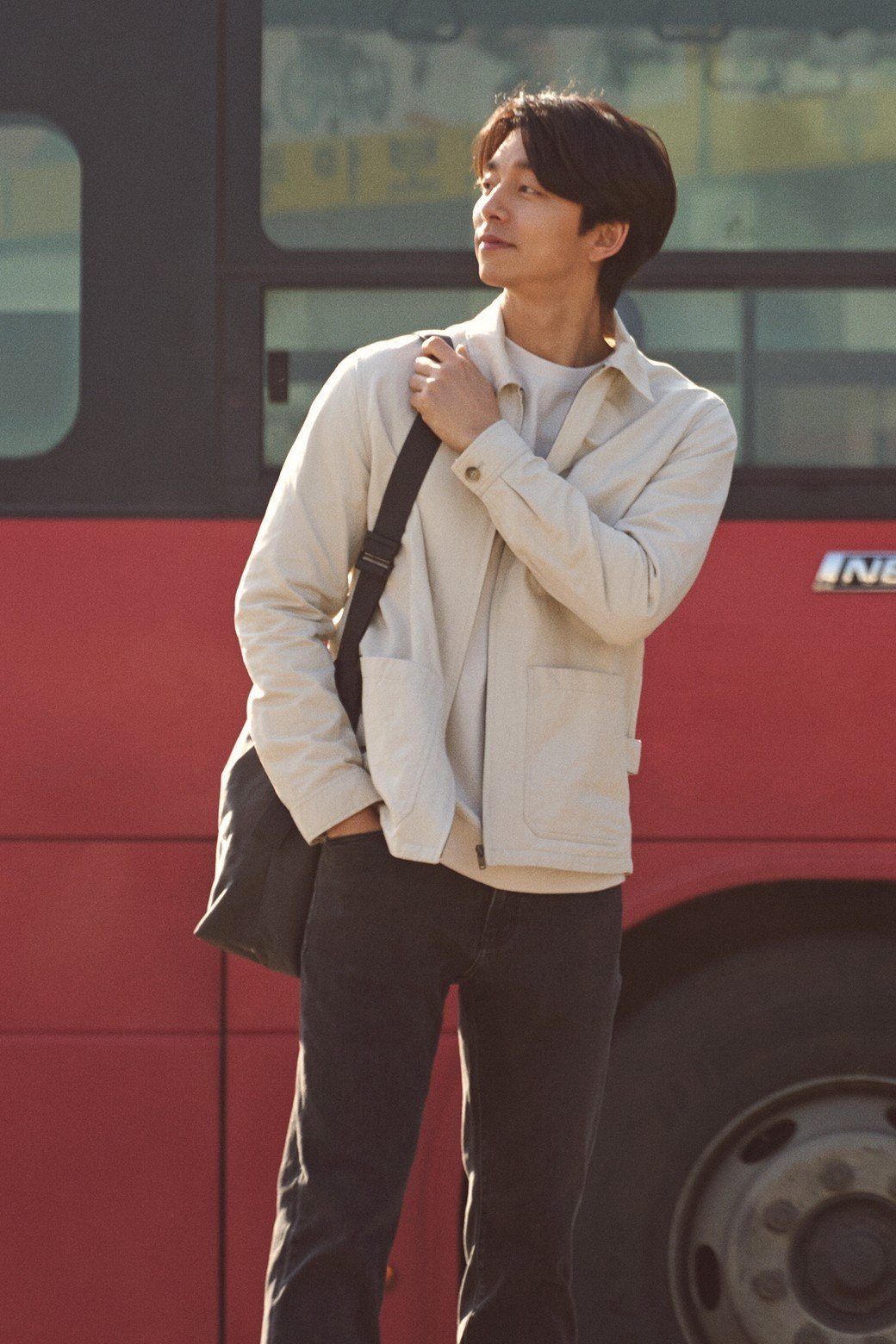 孔刘站在红色公交车旁，肩背黑色包，展现一种休闲而又时尚的风格，为Epigram春季活动增添造型灵感。