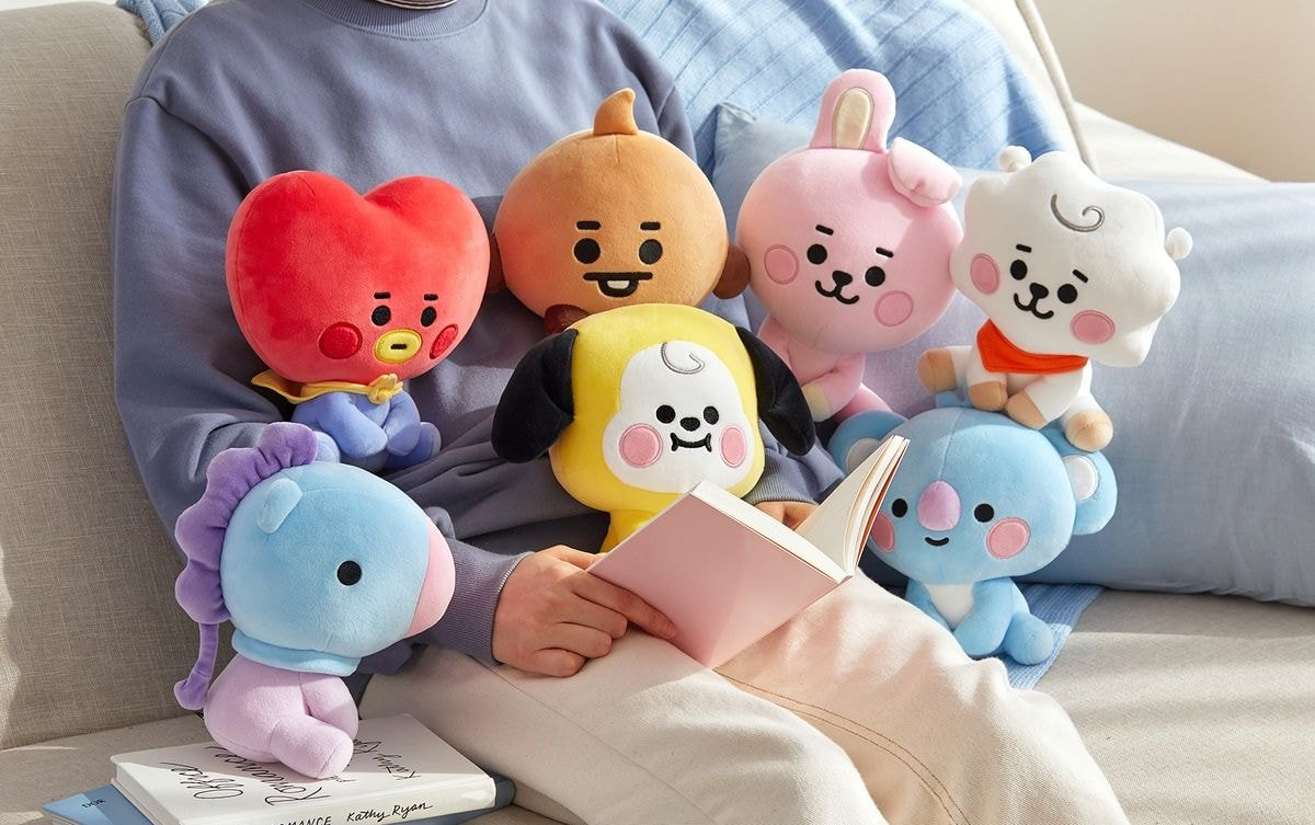 七个BT21 Baby版玩偶围坐在一起，显得十分亲切。这些玩偶包括TATA、CHIMMY、COOKY、RJ、KOYA、MANG和SHOOKY，体现了韩国流行文化的吸引力。
