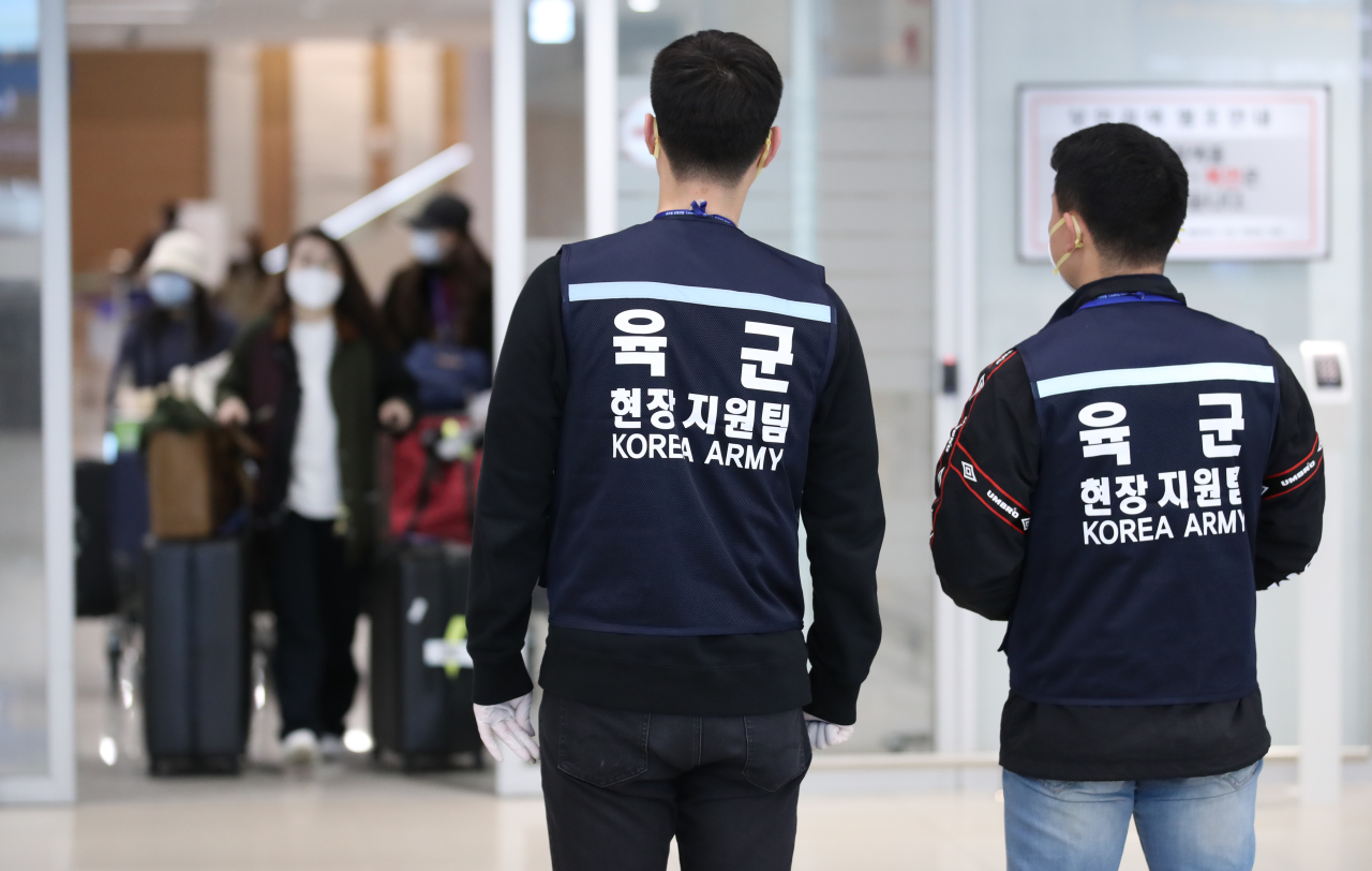 เจ้าหน้าที่ทหารเกาหลีตรวจสอบการเดินทาง ณ สนามบินอินชอนในช่วงการแพร่ระบาดของโควิด-19