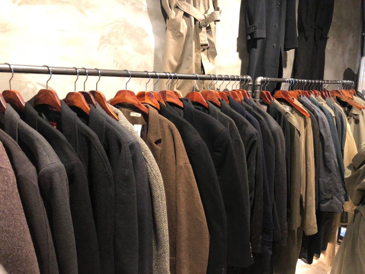 ภาพของเสื้อโค้ทวินเทจแขวนเรียงในแผงร้านค้าที่ตลาดนัดมือสองในโซล