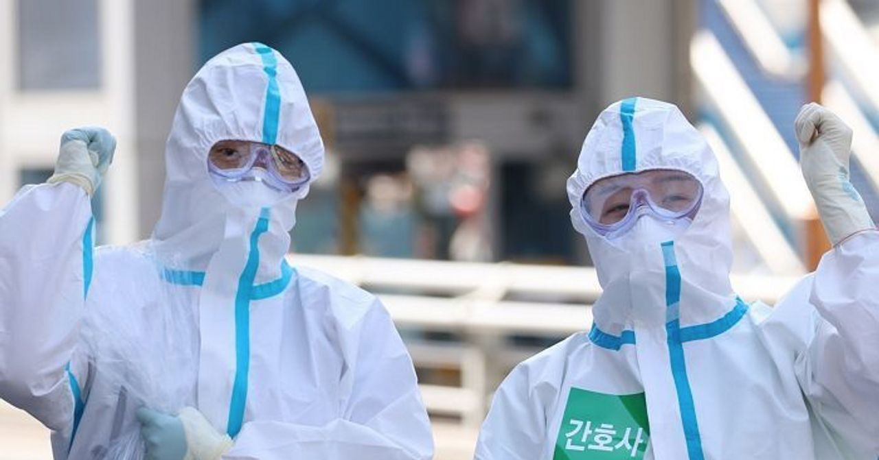 公共健康工作者身穿防護服準備應對新冠疫情，加強防護措施。