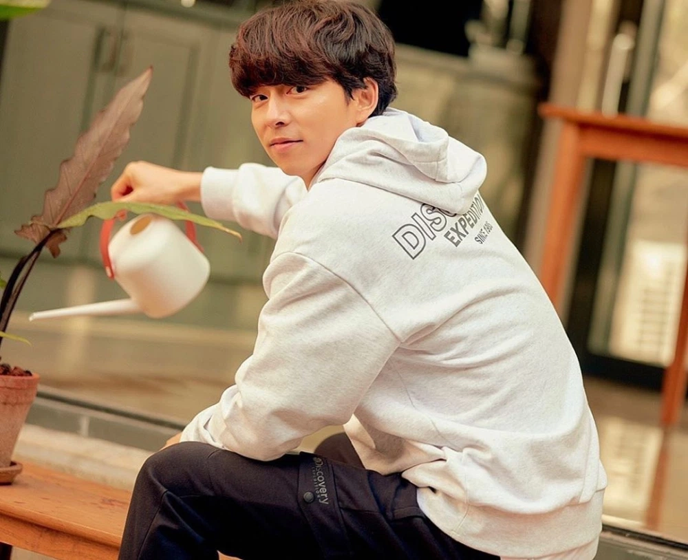 室外场景中的孔刘，身穿Discovery品牌服饰，向前注视，为观众展现坚定和自信的形象。