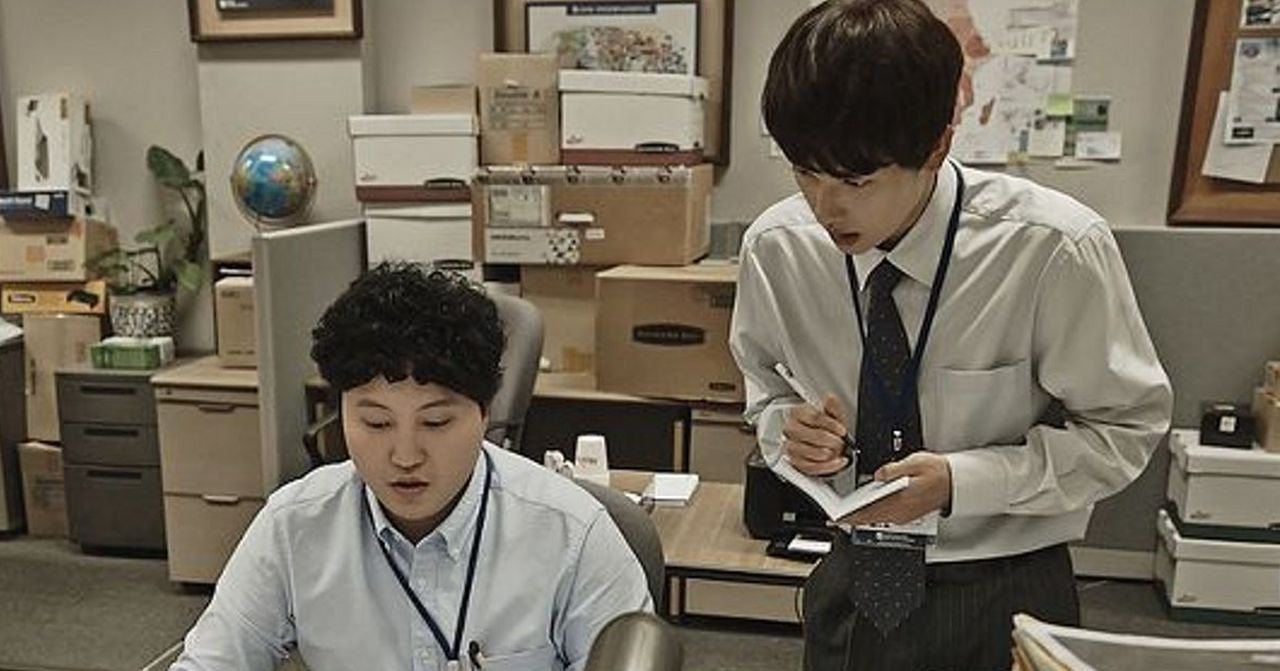 辦公室裡有人在工作，窗外顯示城市景觀。