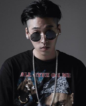 韓国のヒップホップアーティスト、ヤングクリームは、黒いシャツを着て、銀のネックレスを身に着けています。