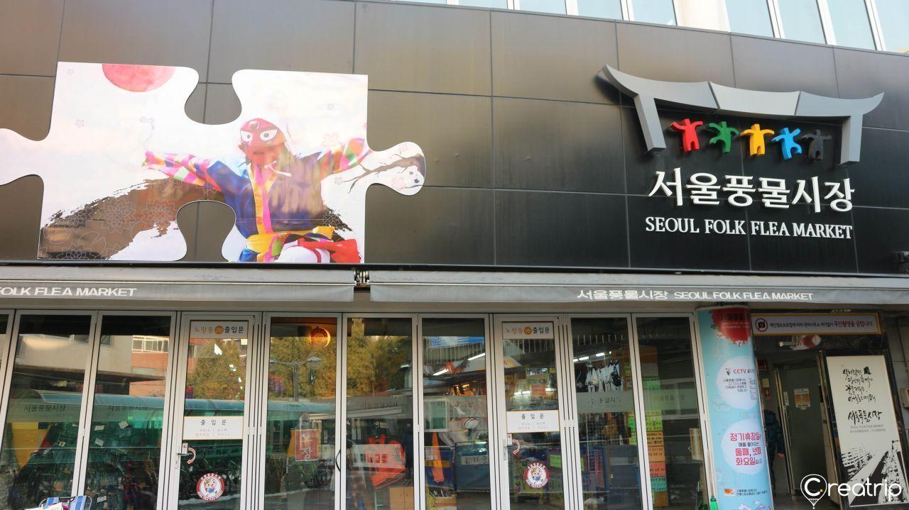 ด้านหน้าตลาดนัดพุงมุลในกรุงโซล ที่มีแผ่นป้ายชื่อและภาพศิลปะติดอยู่บนผนังอาคาร