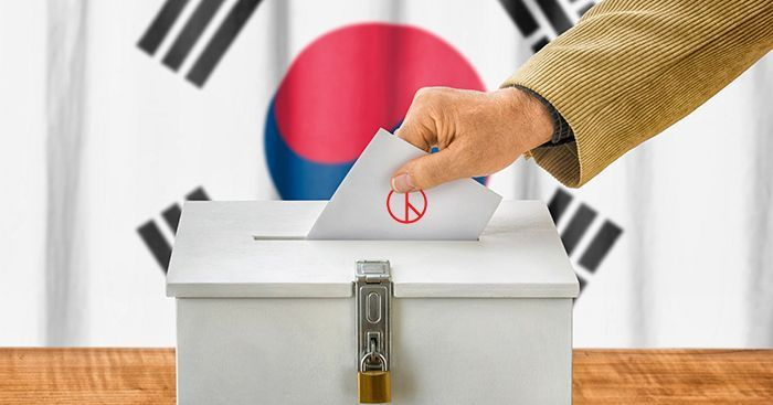 韓國選舉投票的意象圖，展示了手將選票投入箱中