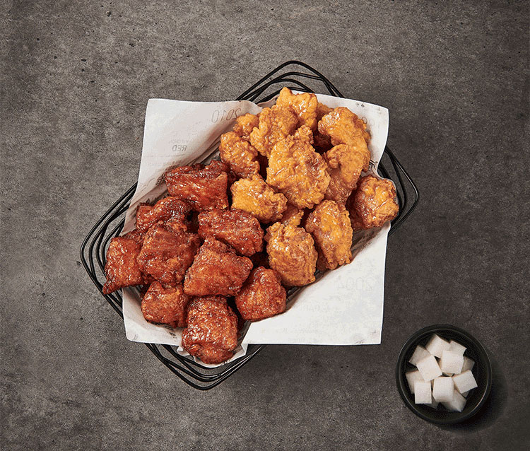 圖中為橋村炸雞推出的全新餐點組合，紅色與蜂蜜口味的半半炸雞搭配蘿蔔塊。這道韓式美食吸引不少食客品嚐。