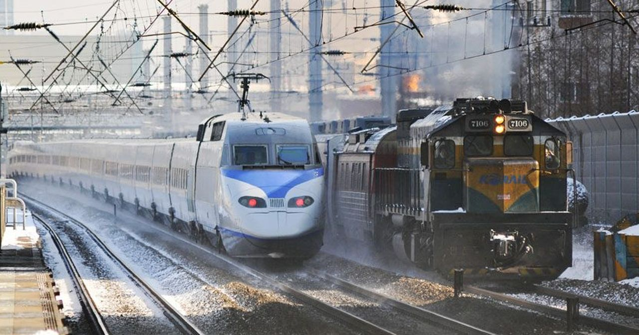 韓國火車站，KTX高速列車與貨物列車並駛，展示韓國公共交通的繁忙。