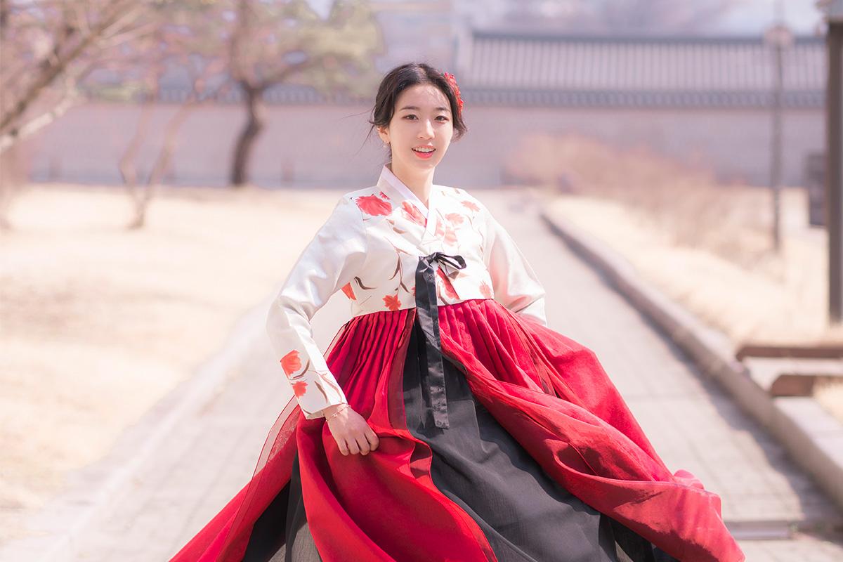 Fashion model wearing Yes Hanbok with a happy smile posing at Gyeongbokgung Palace.