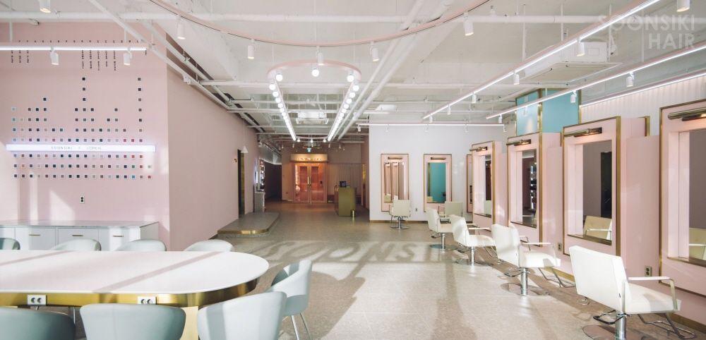 Interior view of 순시키 본점(밤헤드) hair salon featuring modern furniture, unique architecture, and stylish decor elements including chairs, tables, and flooring.