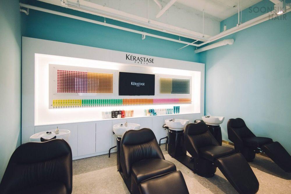 Interior of a modern hair salon with stylish furniture and equipment, including office chairs, desks, and projection screen.