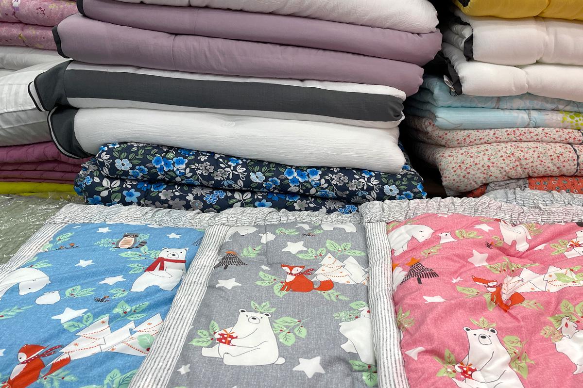 colorful linens with intricate patterns on display at 광장시장 88호 아르페지오, a creative arts and textile shop in Korea.