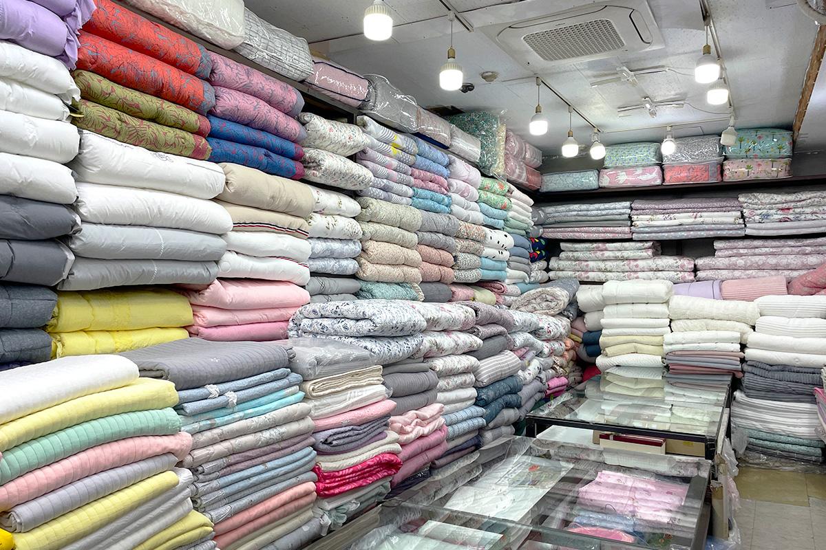 Shelving display at 광장시장 156호 아씨방 featuring a retail collection of paper, stationery, wood, and plastic products in Seoul, Korea.