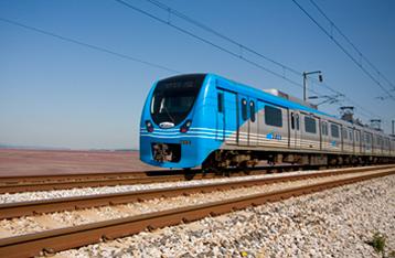 AREX train travels along railway tracks with clear sky and electric wires above.