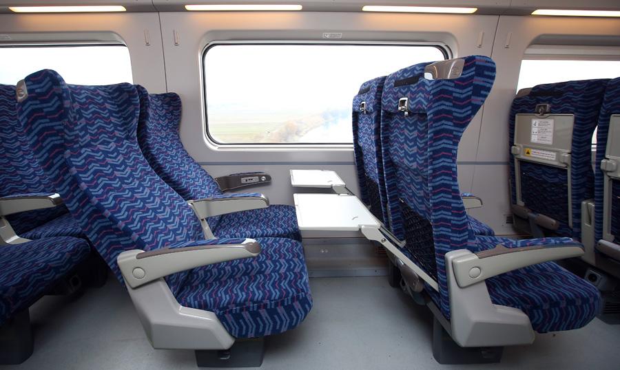 electric blue KTX train with head restraints, seen through a window - mode of public transport in Korea for air travel and motor vehicles.
