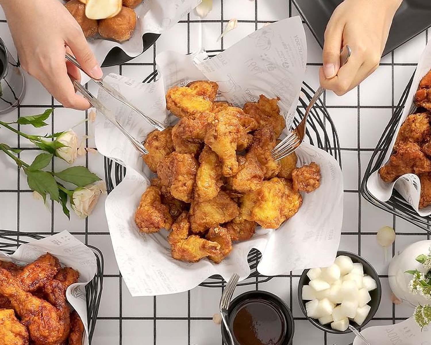 Plate of crispy 교촌치킨 (Korean fried chicken) served with tableware and a deep-fried fritter, perfect for fast food cuisine lovers.