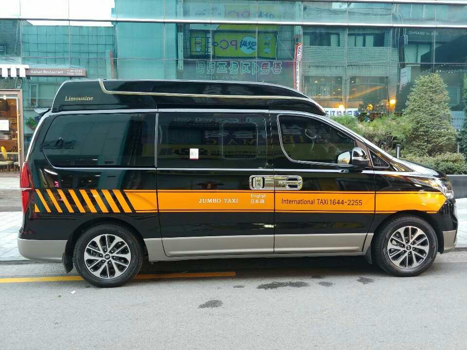 a van with sliding doors parked with taxi sign and automotive lighting and design details visible.