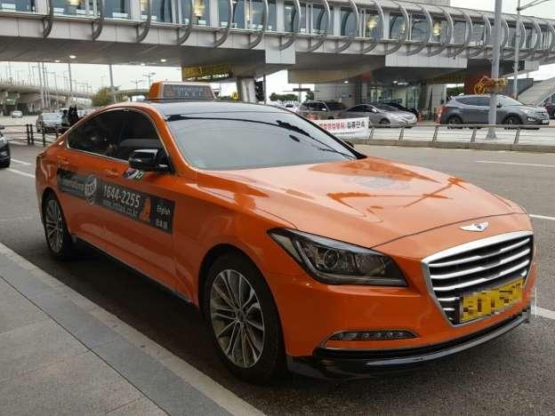 A Seoul taxi at Incheon airport, with a focus on its grille, hood, and tires.