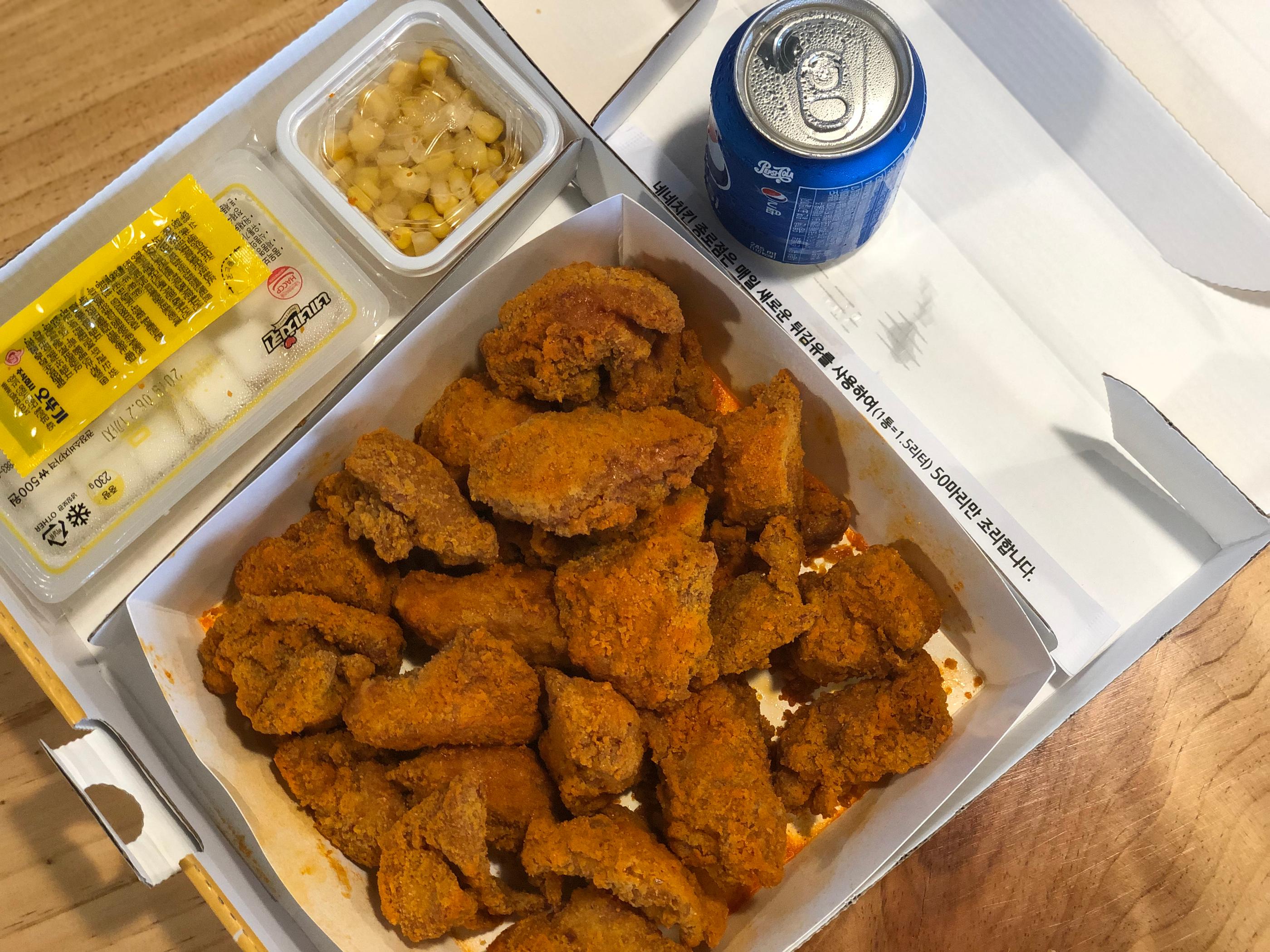 A table filled with Korean fast food, including dishes from Nene Chicken's delivery menu. 