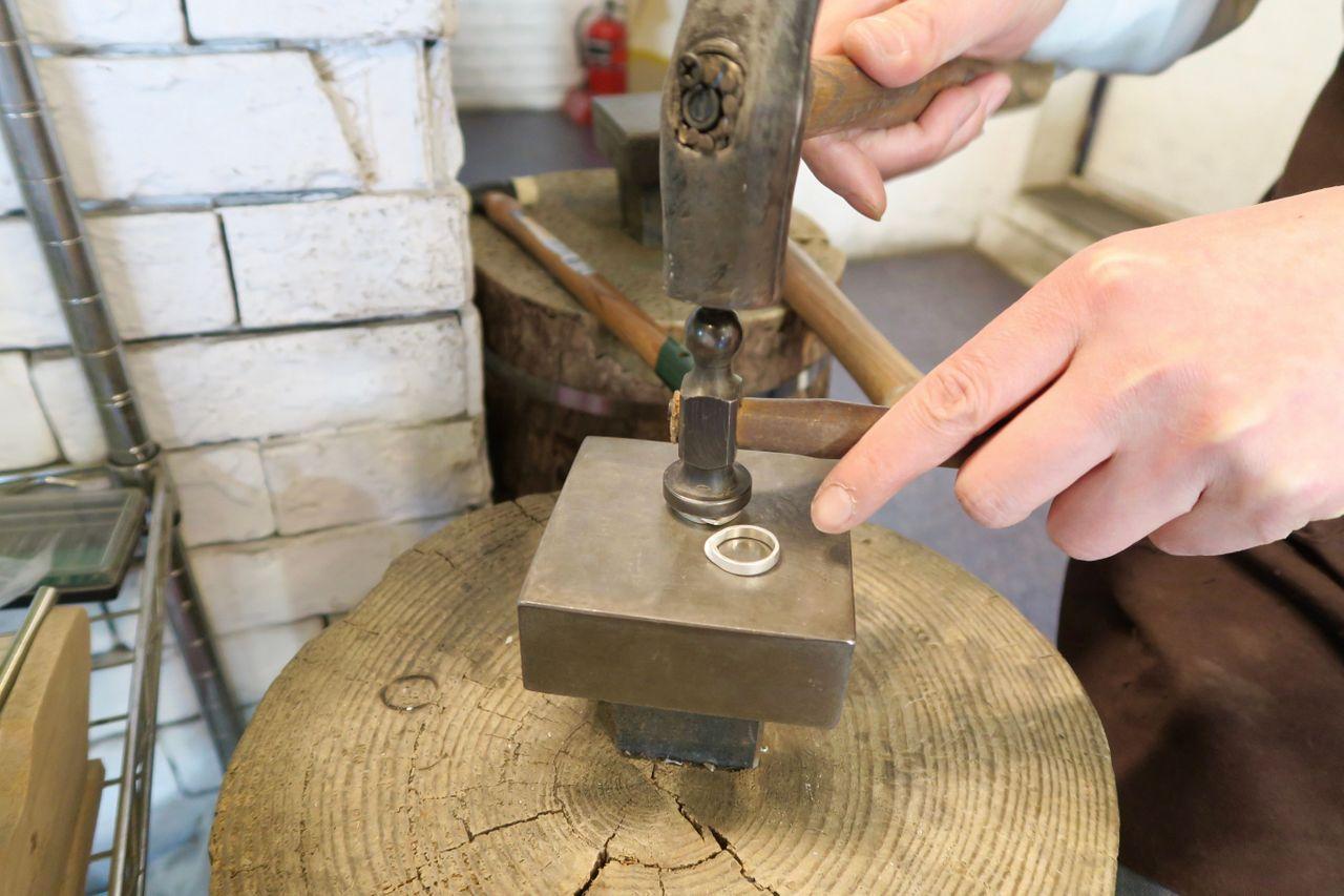 Artisan workshop with wood, metal, and composite materials, featuring a gas-powered machine and workbench. Located in Hongdae, Korea.