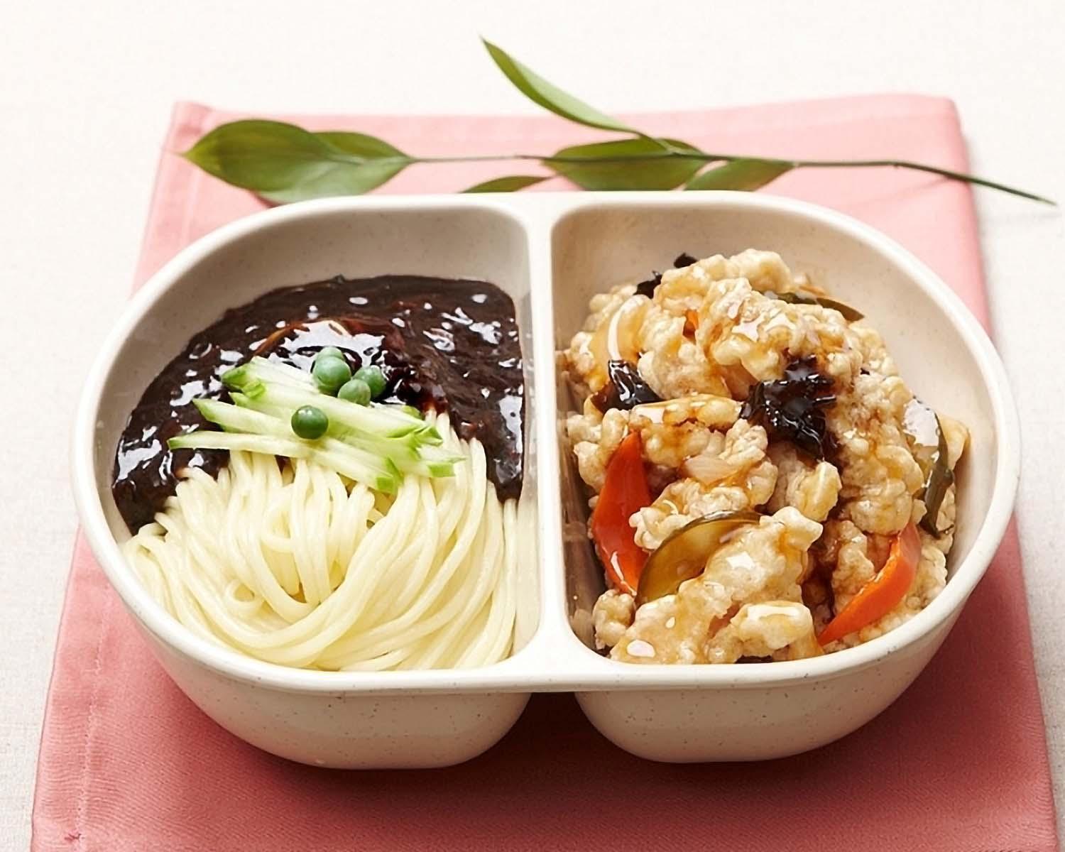Delicious Chinese delivery: enjoy a set of tasty, traditional dishes including noodles, rice, and tangsuyuk in mixing bowls on a table with tableware.