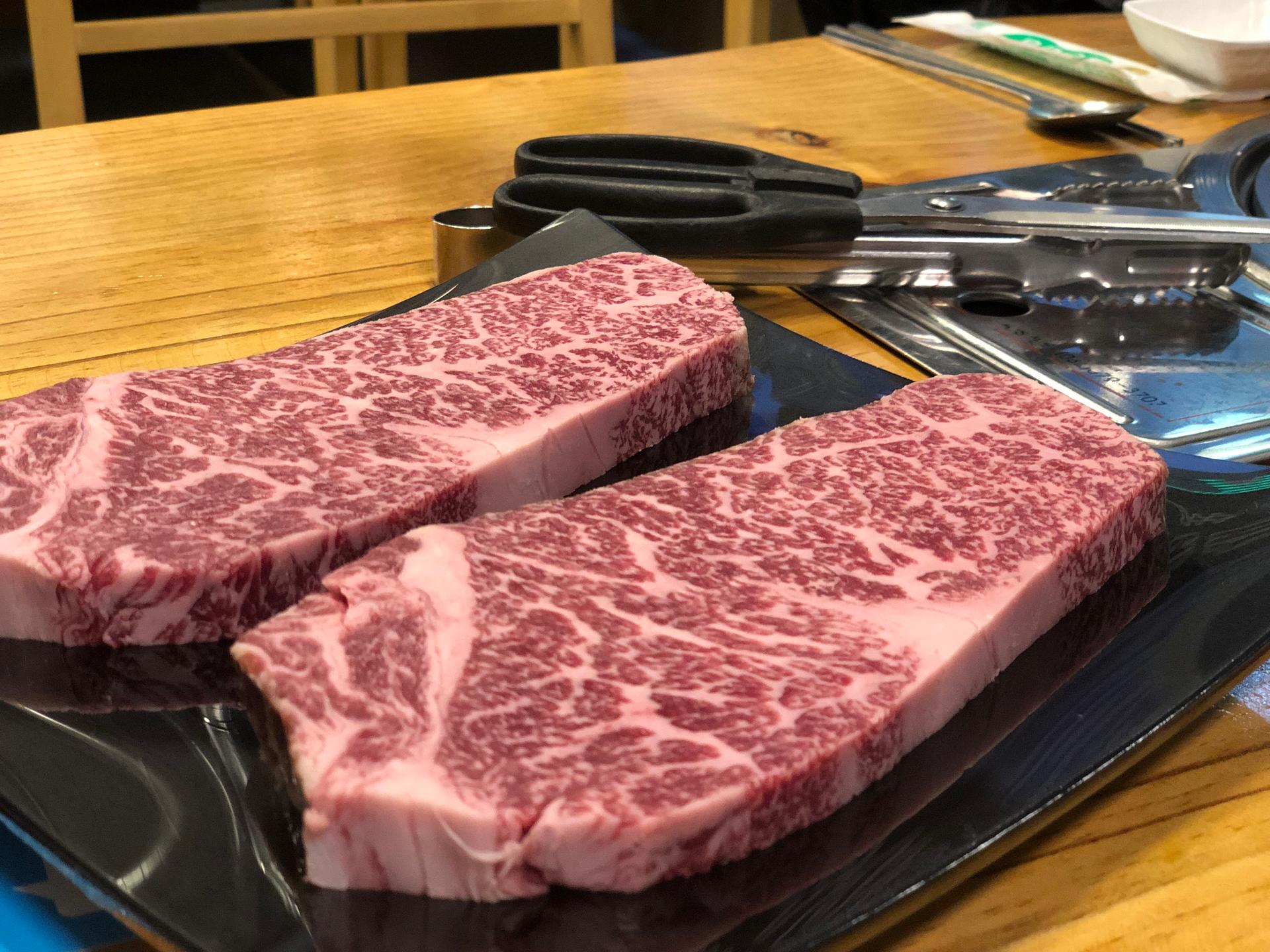 Beef steak and succulent pork served with traditional Korean ingredients at 마장골 restaurant.