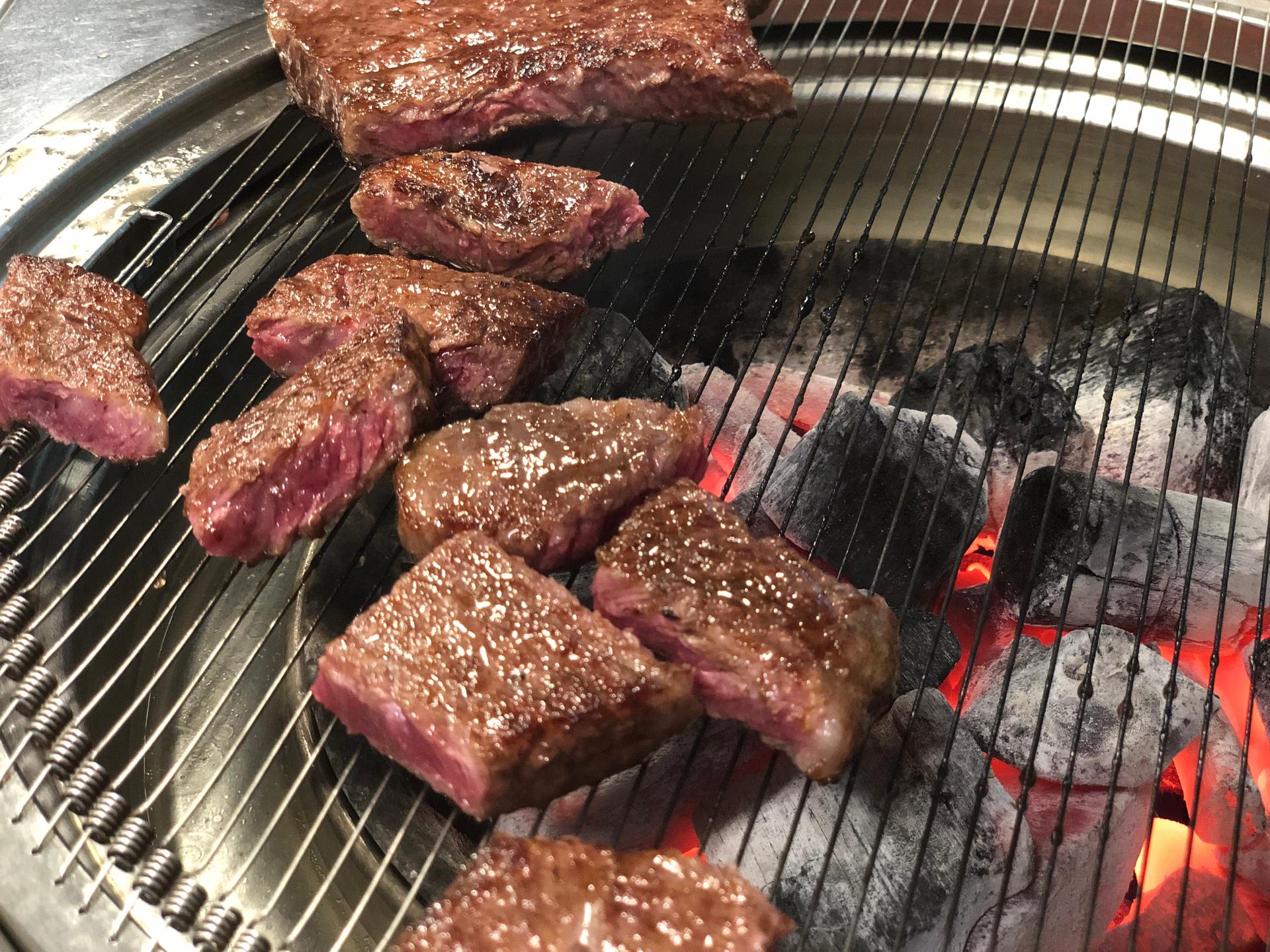 Grilled beef served on a grill. Delicious Korean dish with a recipe and kitchen appliances.