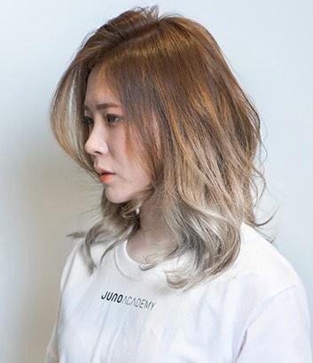 Model showcasing layered hair and bangs at Juno Hair Salon in Centum City, Busan. Nose, lip, shoulder, eyelash, jaw, neck, and sleeve details.