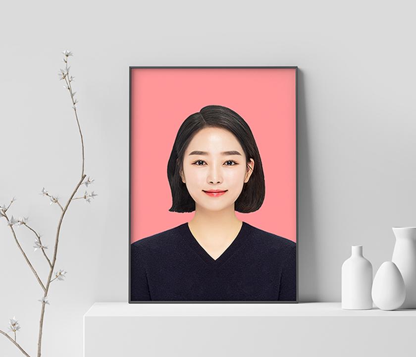Portrait of a woman with a bright smile, wearing makeup and a sleeveless dress, in a rectangular photo frame at a photography studio in Hongdae, South Korea.
