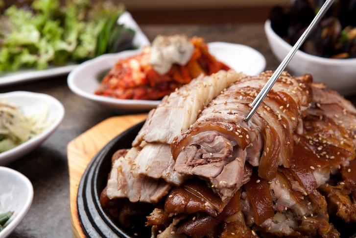 Plate of Korean-style pork and beef with side dishes, available for delivery.