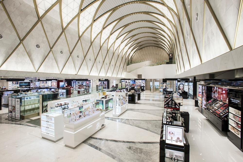 Interior of 롯데면세점(city retail store) with ceiling fixture and window displays, engineered for customer experience.