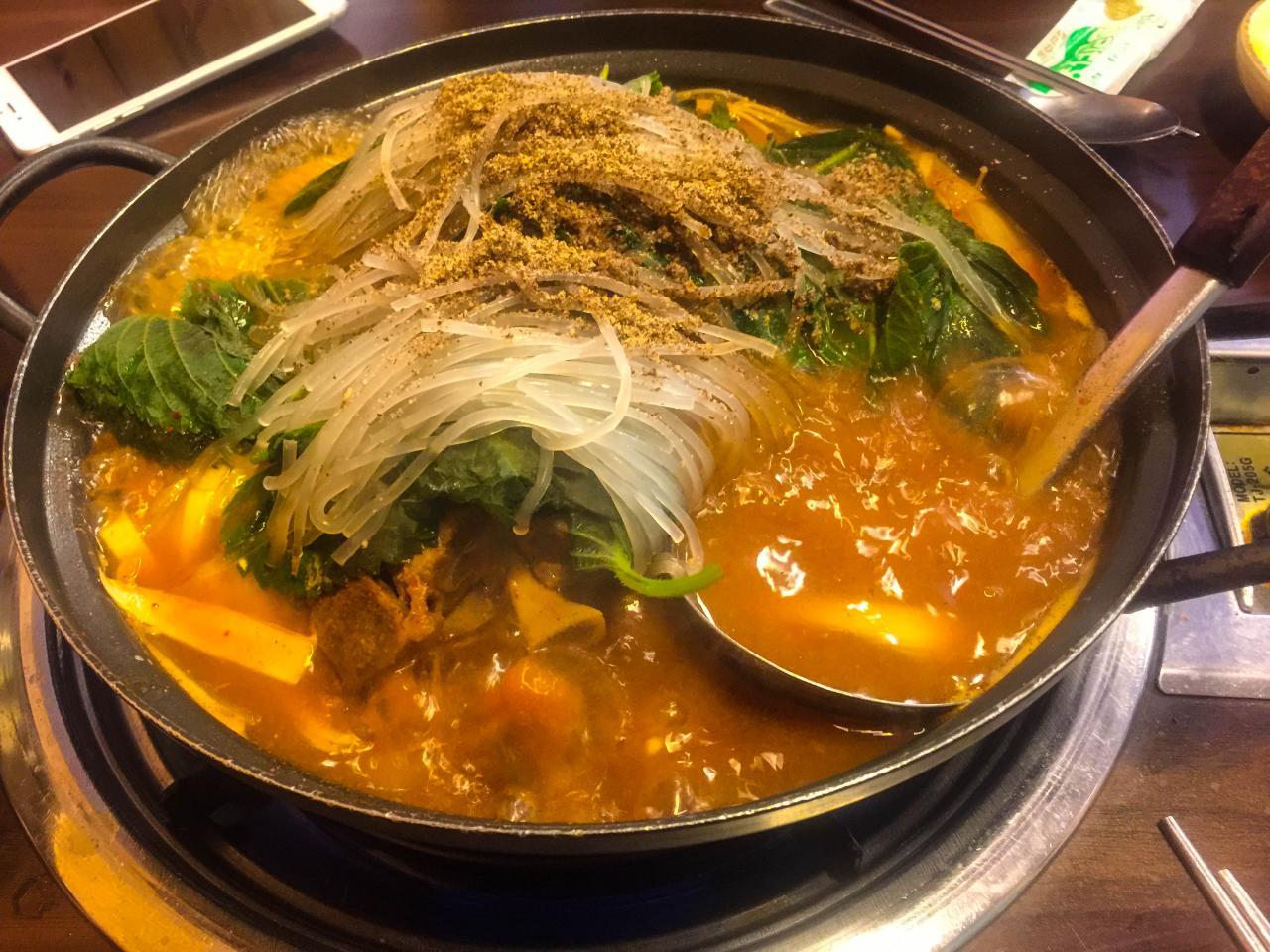 A hearty Korean staple dish - 성균관 감자탕 with noodles, soup, and tableware.