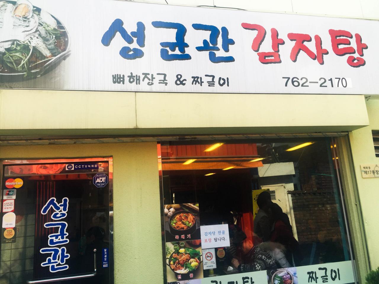 Signage for  'Sungkyunkwan Gamjatang' with fixtures, doors, and advertising.