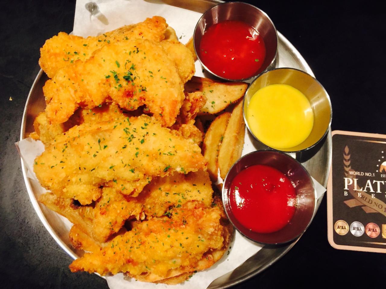 A plate of food from a Korean restaurant with liquid nitrogen cooking technique, beer, and various condiments.