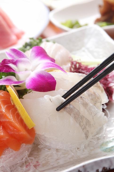 A table with Korean seafood and flower adornments at a restaurant in Noryangjin fish market.