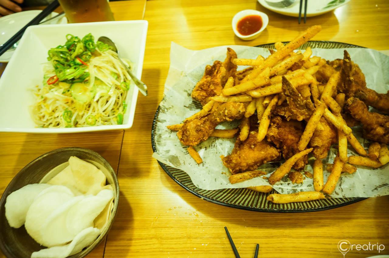 A plate of Saichicken and French fries with tableware on a wood table. Delicious deep-fried staple food in Korea.