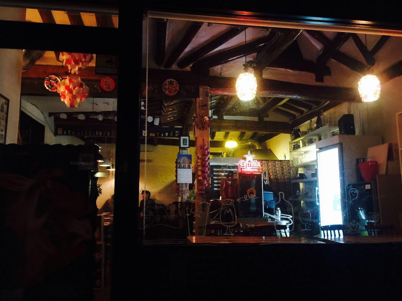 Nighttime drinking establishment Calle De Gomis in 서촌 with dim lighting and hanging light fixtures