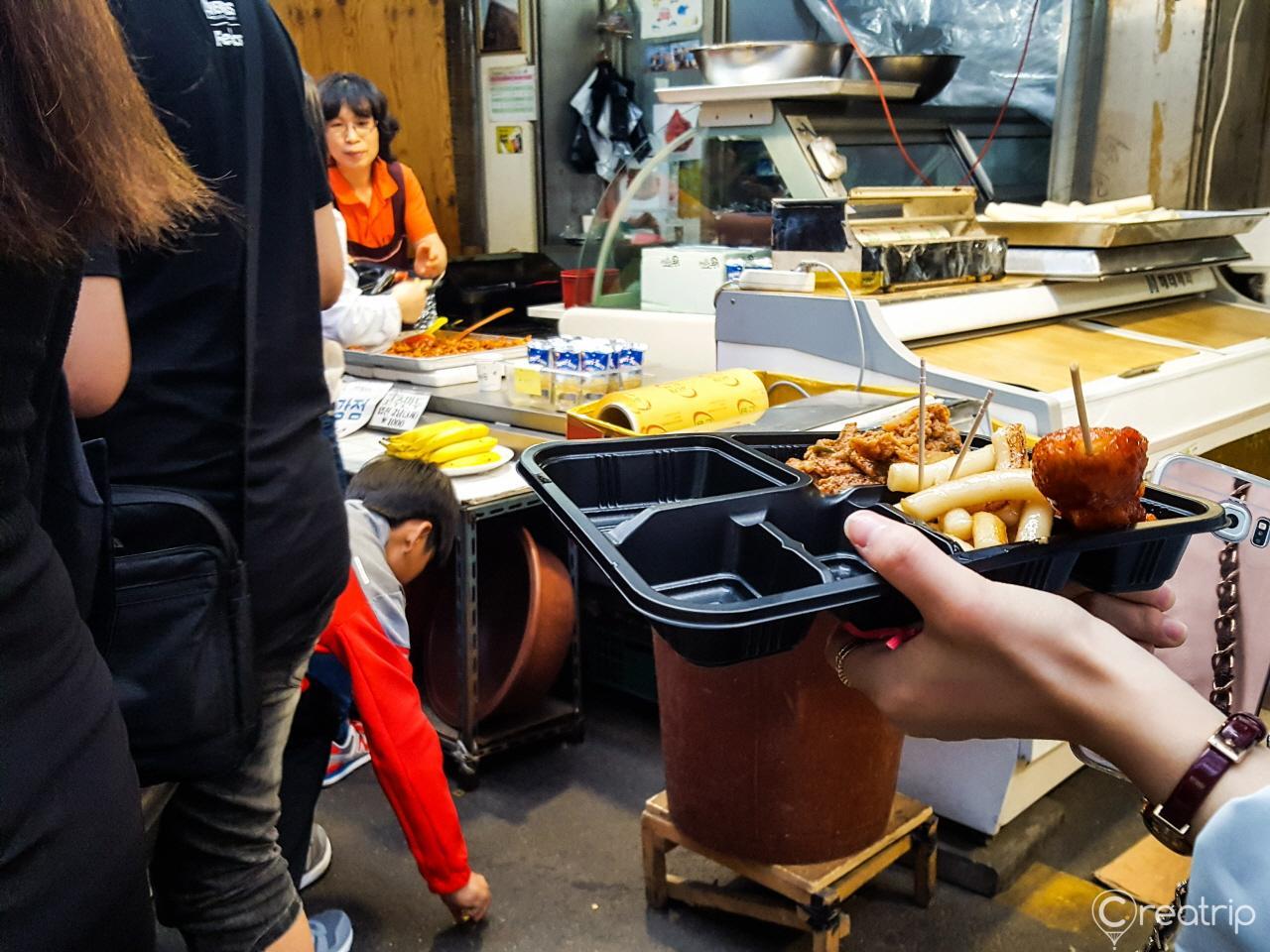 Colorful cuisine and tableware spread on a market stall at the bustling Tongin Market in Korea.