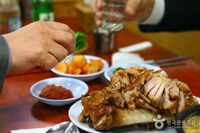 Plate of savory Korean cuisine featuring jokbal in the vibrant food alley of Gongdeok district.