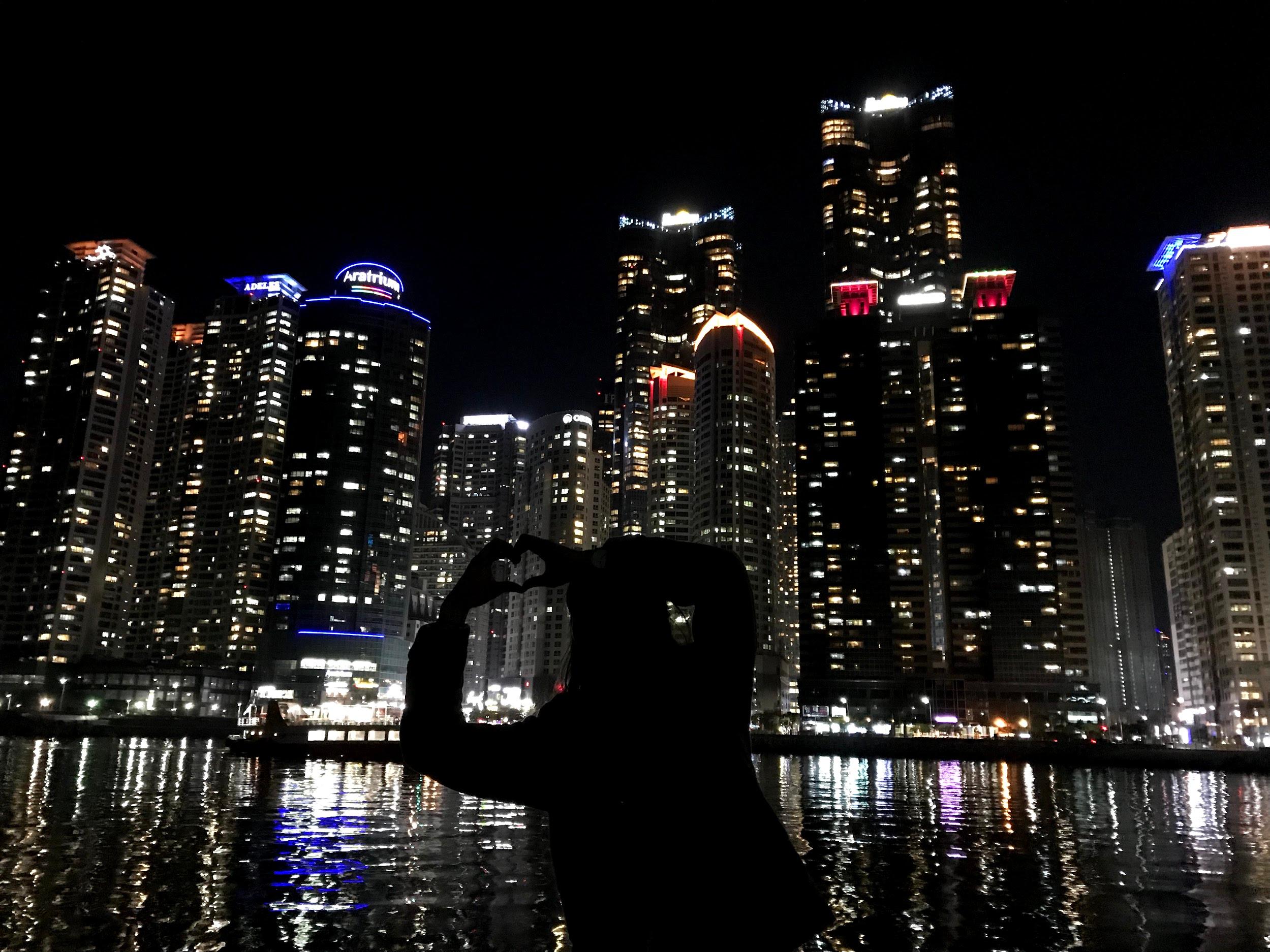 Skyscraper towering over nature with water and cityscape in the background.