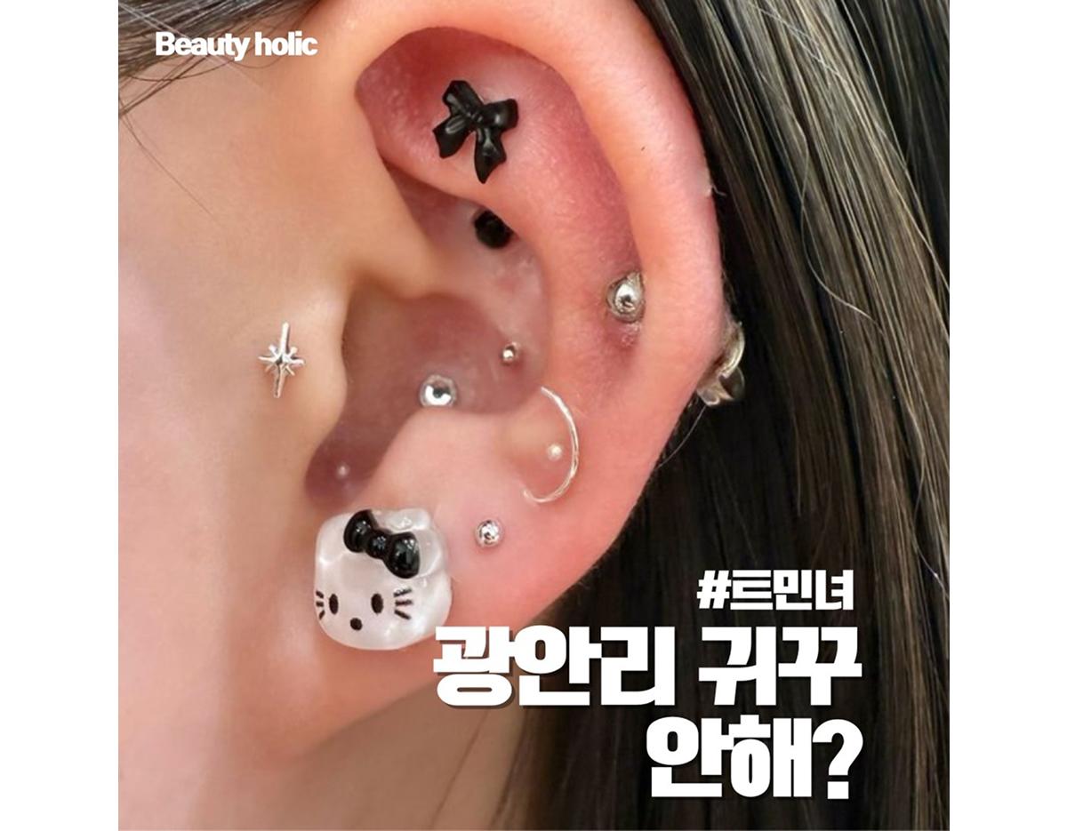 close-up of ear with white spotted beach-themed ear accessory and long highlighted brown hair, text overlay in Korean