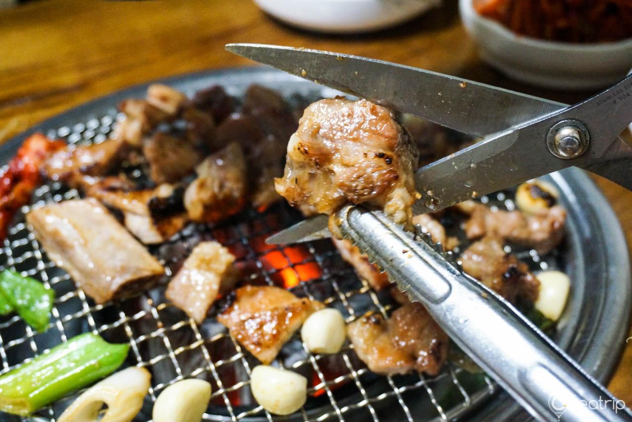 A sizzling plate of 대성갈비 on an outdoor grill rack & topper. Perfect for any meal.