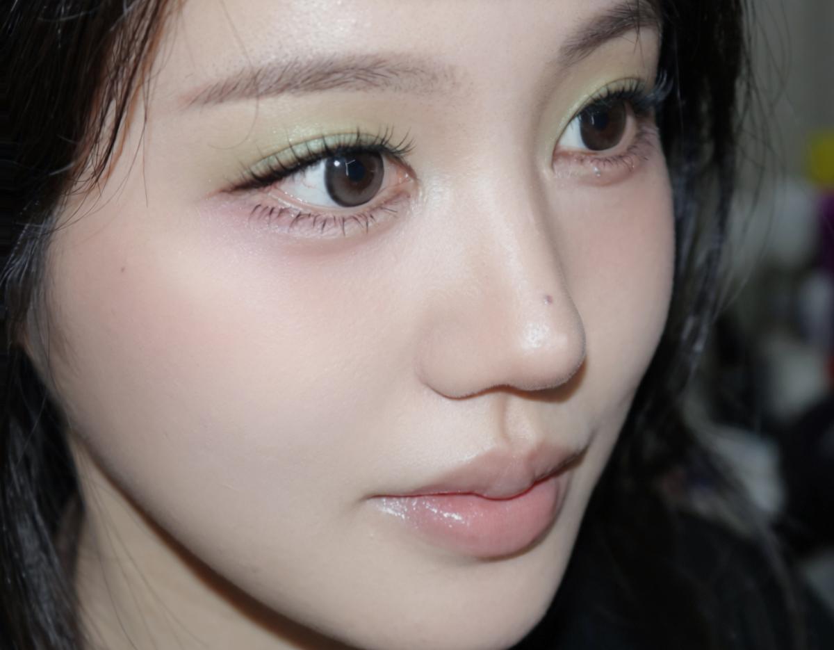 Close-up of a woman's face with natural pink lips, soft blush, and green eyeshadow applied by ORARE Cheongdam salon.