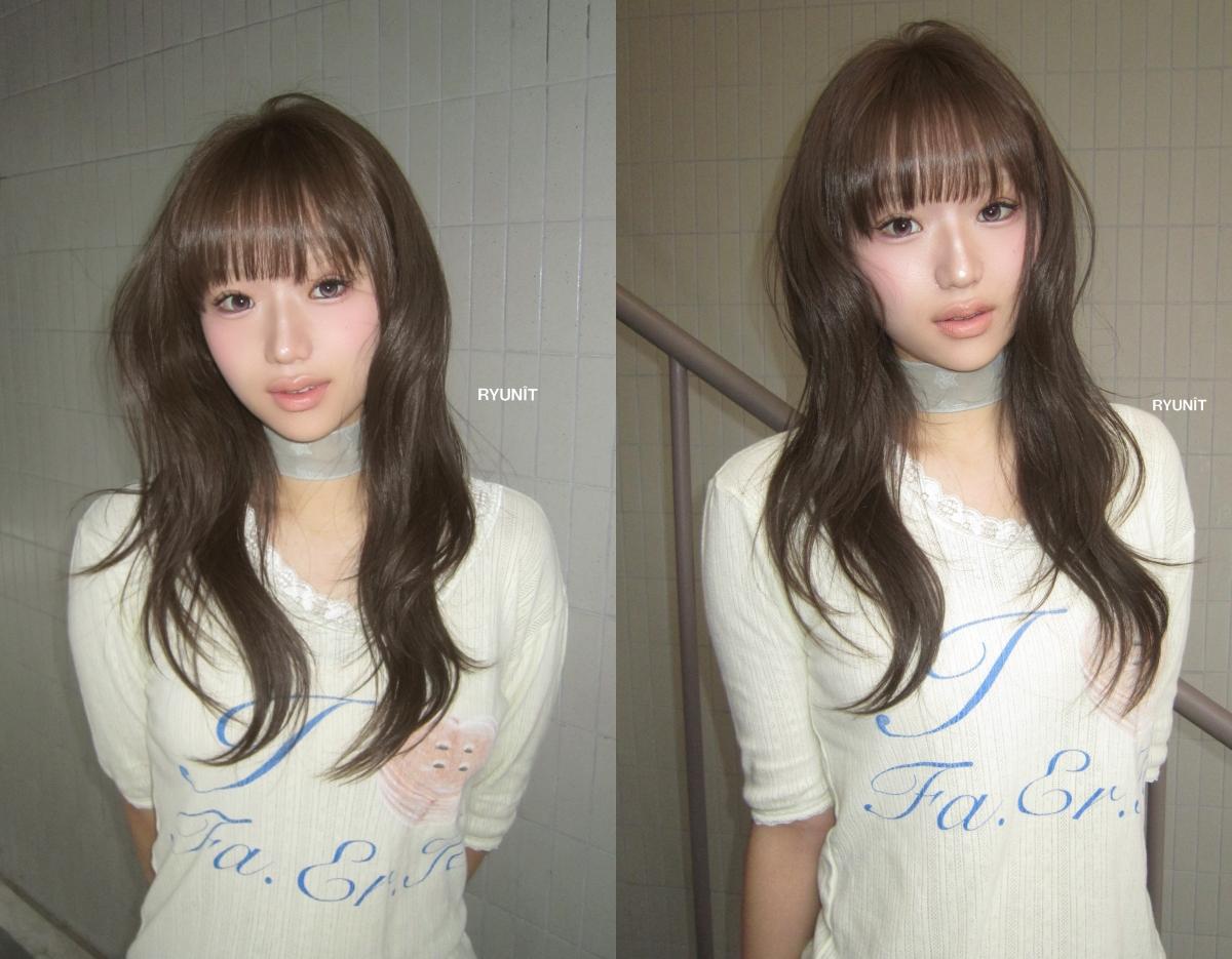 shoulder-length layered brown haircut with soft waves and curtain bangs on a woman wearing white sweater
