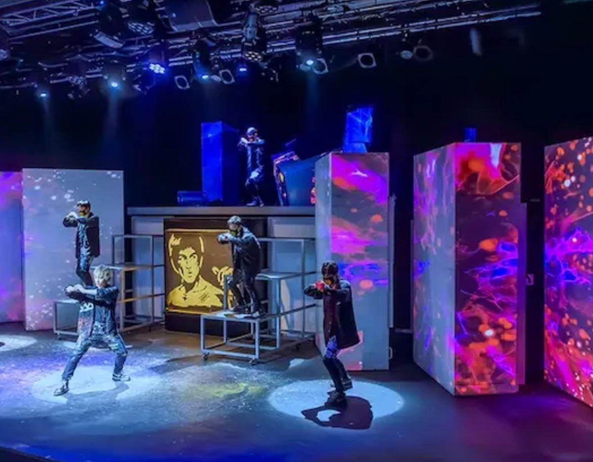 K-pop style stage performance with dancers in dark outfits and colorful LED panels and spotlights at Seoul Culture Lounge