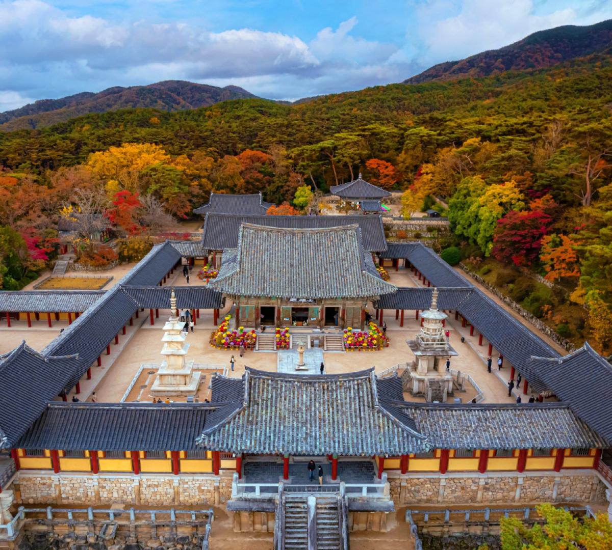 Bulguksa temple complex in Gyeongju seen from above with tiled roofs, stone pagodas and autumn trees surrounding hills