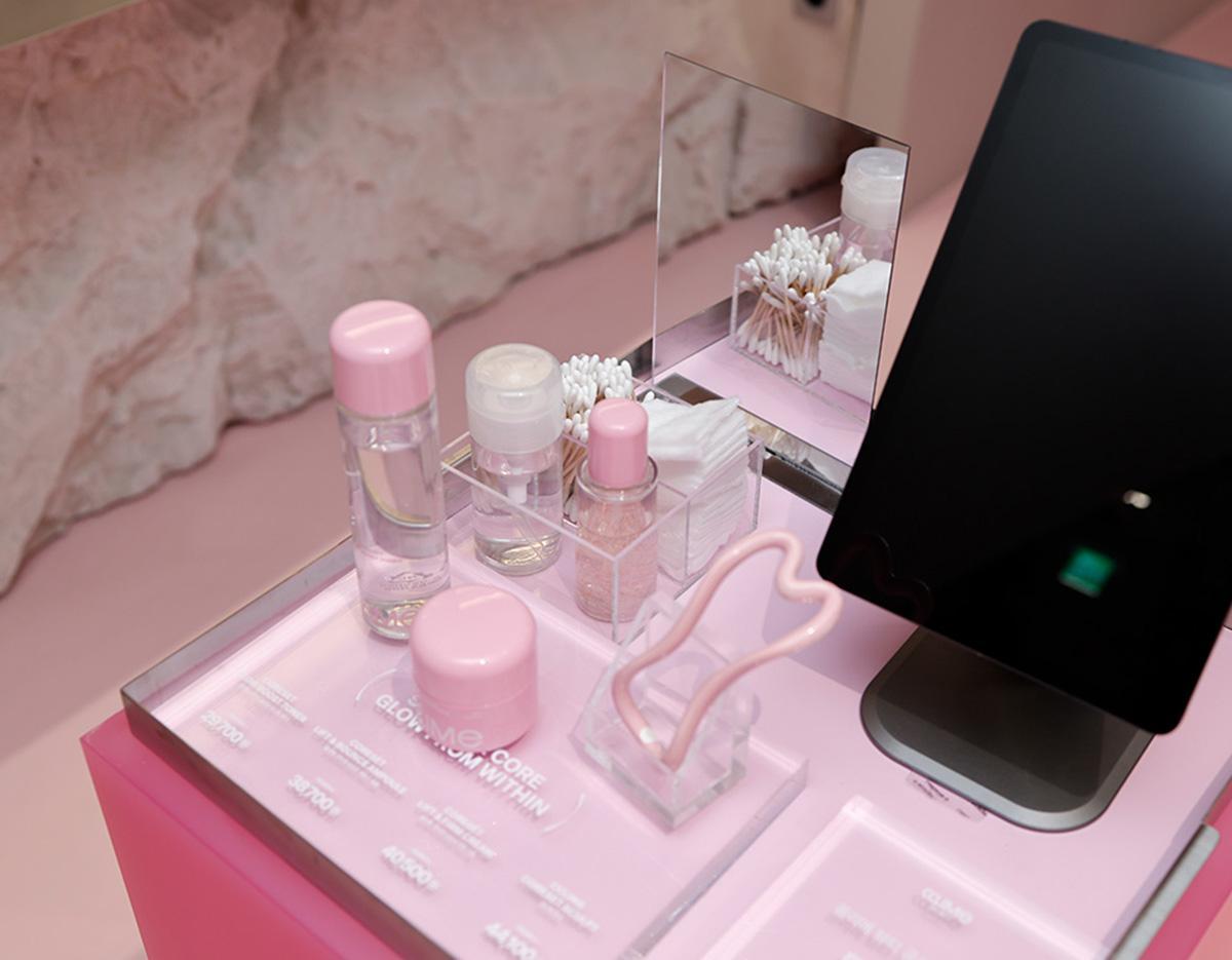 therapist's hands massaging a client's oiled jawline and neck over a gray towel at a beauty esthetic clinic