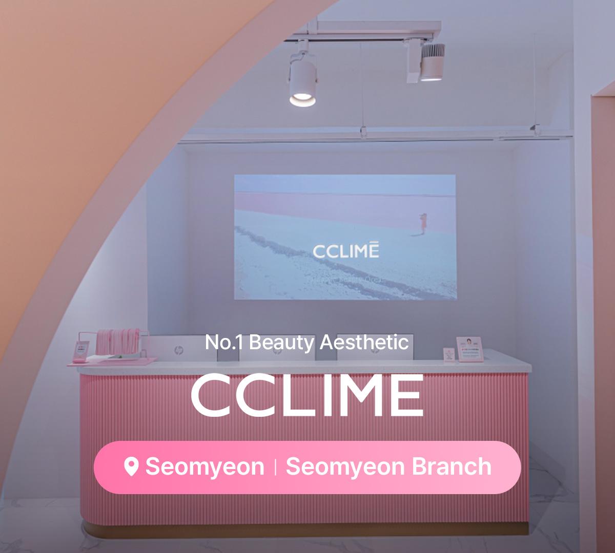 therapist's hands holding a gold dual-ball facial massage tool against a client's jawline on a treatment bed