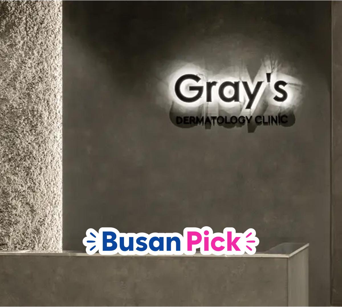 Gray's Dermatology Clinic reception wall with illuminated clinic logo and minimalist concrete counter